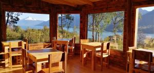 a restaurant with tables and chairs and a view of a mountain at Patagonia Nativa in Cochamó +12 photos