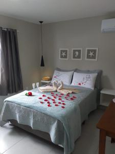 Un dormitorio con una cama con rosas rojas. en Pérola de Bombinhas, en Bombinhas