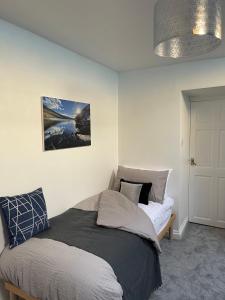 a bedroom with a bed and a pendant light at Mynydd A Môr in Trevor