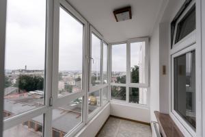 a room with windows with a view of a city at Тиха та комфортна квартира in Ternopilʼ