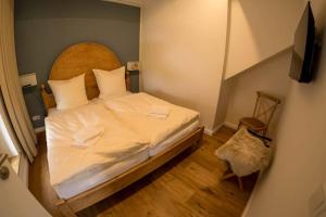 Dormitorio pequeño con cama con cabecero de madera en Zum Heuerling Ferienwohung im alten Stall mit Sauna en Versmold