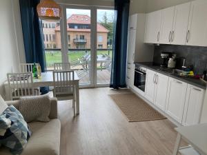 eine Küche mit einem Sofa und einem Tisch sowie eine Küche mit einem Fenster in der Unterkunft Wohnen am Südstrand - Ferienwohnung 1 6 in Wyk auf Föhr