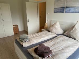 - une chambre avec 2 lits et des serviettes dans l'établissement Wohnen am Südstrand - Ferienwohnung 1 6, à Wyk auf Föhr