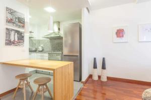 a kitchen with a wooden counter and a refrigerator at SUN RAMBLA CATALUNYA GAUDI Limpieza Desinfección in Barcelona