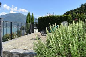 uma passagem de pedra com um banco e uma cerca em Apartment Monte e Lago em Pianello Del Lario