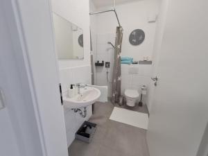 a white bathroom with a sink and a toilet at Pension am Rathaus, 24h Check-IN in Mundelsheim