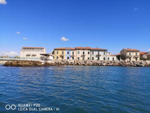 un grupo de casas en la orilla de un cuerpo de agua en bilocale Marina di Pisa en Marina di Pisa