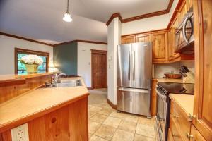 a kitchen with wooden cabinets and a stainless steel refrigerator at Le Plateau by Rendez-Vous Mont-Tremblant in Mont-Tremblant