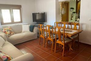 een woonkamer met een tafel en stoelen en een bank bij Casa Cactus Preciosa casa rural con piscina y exterior privado muy amplio in Granada