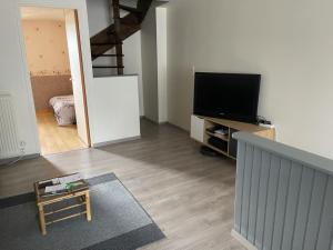 een woonkamer met een flatscreen-tv op een entertainmentcentrum bij Chambre double avec WiFi châtellerault in Châtellerault