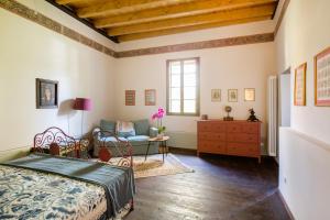 a bedroom with a bed and a couch and a table at Villa Guarienti Valpolicella in Fumane