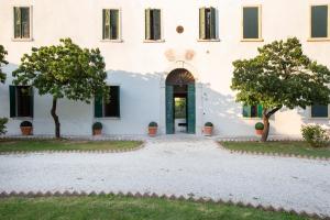un gran edificio blanco con árboles delante de él en Villa Guarienti Valpolicella, en Fumane