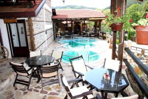 eine Terrasse mit einem Tisch, Stühlen und einem Pool in der Unterkunft Hotel Manastir Berovo in Berovo