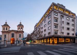 a white building with lights on the side of a street at Windsor Hotel in Córdoba