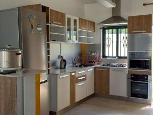 a kitchen with white cabinets and a stove top oven at Bungalow at Pereybere in Grand-Baie