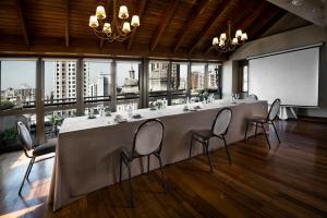 a long table with chairs in a room with windows at Windsor Hotel in Córdoba +37 photos