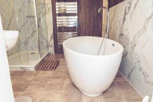 a bathroom with a tub and a shower and a sink at 3-Bed Cottage-Plymouth-Dog friendly-Sleeps7 in Plymouth +17 photos