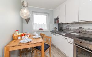 une cuisine avec une table en bois, des chaises et un comptoir dans l'établissement Deichkieker Whg 17, à Sankt Peter-Ording