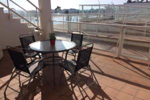 un tavolo e sedie su un balcone con vista di Bonito apartamento en primera línea de campo de golf y vistas al mar a Mojácar