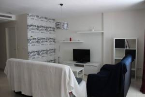 un soggiorno con divano e TV di Bonito apartamento en primera línea de campo de golf y vistas al mar a Mojácar
