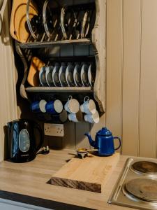 a kitchen counter with cups and utensils on a shelf at Beautiful Grade II Listed Gatehouse in Great Location in Sheffield