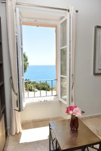 een vaas met bloemen op een tafel voor een raam bij Luxurious/design house sea view old Antibes for 6 in Antibes