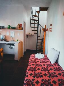 a bedroom with a bed with a red comforter and a sink at Altos Valles del Sol in Cafayate