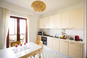 a kitchen with white cabinets and a table with wine glasses on it at Casa Vivienne in San Vitaliano 