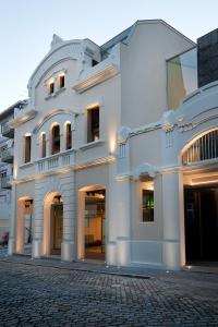 een wit gebouw op een geplaveide straat bij Hotel Fabrica do Chocolate in Viana do Castelo