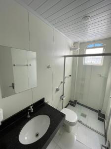 uma casa de banho com um lavatório e um WC em Real Hotel em Sete Lagoas
