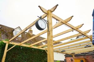 a wooden pergola with a clock on it at The Coachmakers Arms in Wallingford
