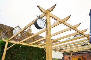 Una pérgola de madera con un reloj. en The Coachmakers Arms, en Wallingford