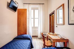 a bedroom with a table and a bed and a table and chairs at Hotel Nuova Italia in Florence
