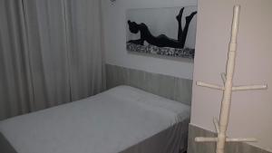 a small room with a bed and a cross on the wall at HOSPEDARIA CONSULADO PAULISTA in Taíba