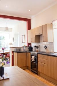 a kitchen with wooden cabinets and a stove top oven at Abbotshill, Dalvey Estate in Forres