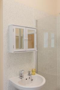 um lavatório de casa de banho com um armário branco por cima em Abbotshill, Dalvey Estate em Forres
