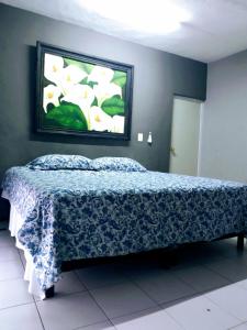 ein Schlafzimmer mit einem Bett mit einer blauen und weißen Decke in der Unterkunft Casa Ixchel - 700m to Downtown, WiFi, Hot Water, AC in Valladolid