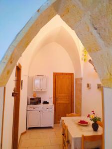 una cocina con un arco y una mesa en La Dimora della nonna Rosina, en Galatone