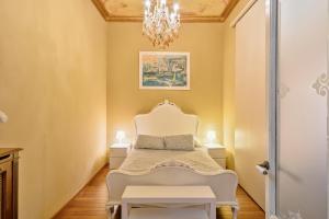バルセロナにあるAribau Apartmentのベッドルーム(白いベッド1台、シャンデリア付)