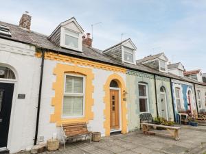 eine Häuserreihe mit einer Bank davor in der Unterkunft Bay Cottage in North Shields