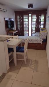 Zimmer mit einem Tisch und einem Bett mit einem Schreibtisch in der Unterkunft Praia do Forte Kauai Bahia in Praia do Forte