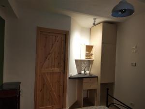een kamer met een deur, een tafel en een koelkast bij Antico Portale Ospitalità Diffusa in Acquasparta