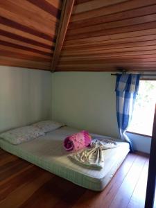 a bed in a room with a wooden ceiling at Pousada Jambo Trindade in Trindade