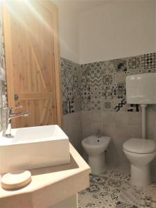 baño con lavabo, aseo y puerta en Antico Portale Ospitalità Diffusa, en Acquasparta