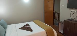 um quarto com uma cama com um guardanapo castanho em Hotel Sonar Tori em Gangtok