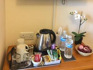 a table with a coffee pot and other items on it at Chaston Manor Hotel in Sandown