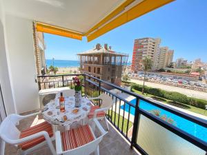 einen Balkon mit einem Tisch und Stühlen sowie Meerblick in der Unterkunft Modern 1 Bedroom Seaside Apartment with Pool in Fuengirola