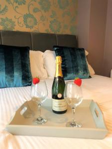 a bottle of champagne and two glasses on a bed at Blue Anchor House in Maryport