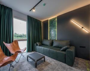 ein Wohnzimmer mit einem grünen Sofa und Stühlen in der Unterkunft Joy 5 Hotel & SPA in Belgrad