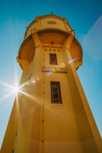 a lighthouse with the sun shining behind it at Apartman Stari Toranj in Vukovar